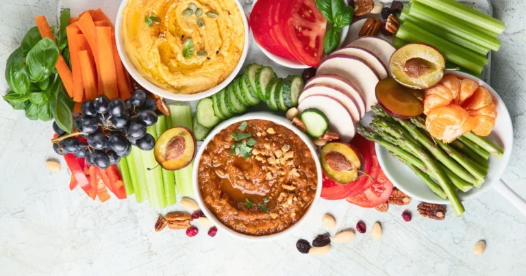 Healthy vegan snacks ideas and dips. Flatlay of party food. Top view on gray background with copy space. Clean diet eating, veggie serving table